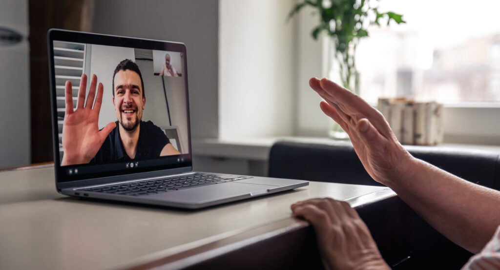 A retired old woman communicates via video call with her son, uses laptop, technology concept.